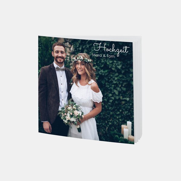 Das RUCK ZUCK Fotobuch® zeigt ein Hochzeitspaar im Freien mit Blumenstrauß, perfekt für romantische Hochzeitsmomente.