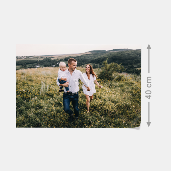 Eine Familie läuft lachend durch eine grüne Wiese – lebendige Erinnerung als hochwertiger Fotoabzug gedruckt.